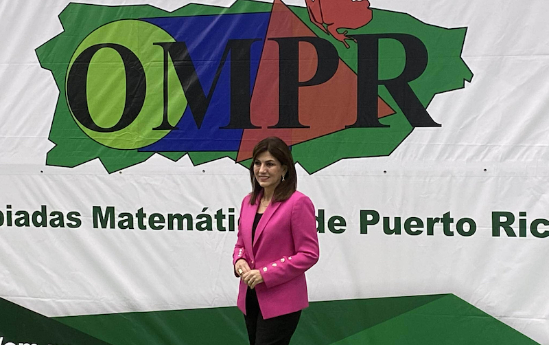 Ada Monzón frente al logo OMPR