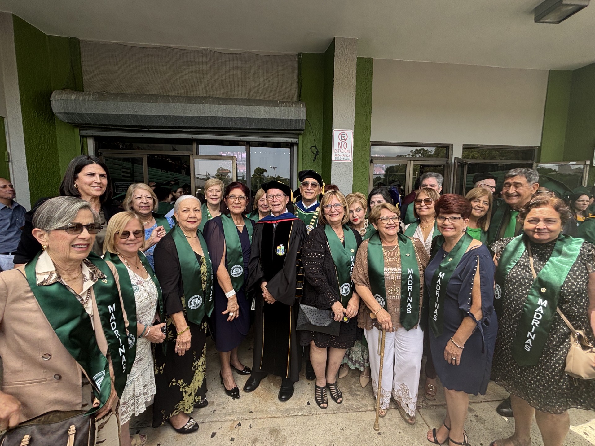 Graduados del Colegio en 1975 posan de pie en la entrada posterior del Coliseo Mangual durante la reciente graduación.