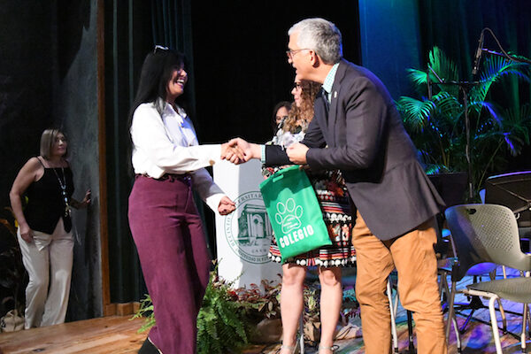 Una empleada recibe el pin de reconocimiento por sus años de servicio en el Colegio. Le da la mano el rector del RUM, doctor Agustín Rullán Toro.