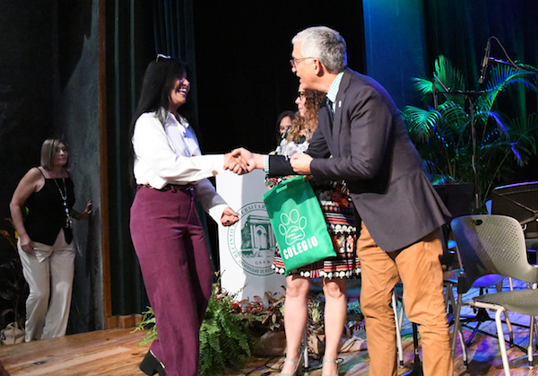 Una empleada recibe el pin de reconocimiento por sus años de servicio en el Colegio. Le da la mano el rector del RUM, doctor Agustín Rullán Toro.