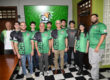 Varios integrantes de la organización estudiantil de videojuegos UPRM Esports, junto al rector del RUM, doctor Agustín Rullán Toro, el profesor José ‘Tito’ Estévez, y el entrenador Félix ‘Pompi’ Vega. Todos de pie, con sus uniformes y con el logo del colectivo proyectado al fondo en una pantalla.