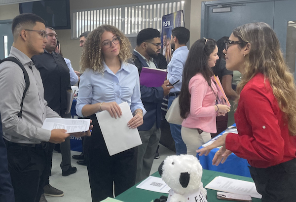 Una reclutadora conversa con dos estudiantes durante la feria de empleos del Colegio de Administración de Empresas en el RUM.