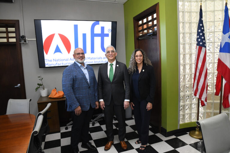Desde la izquierda: el CFO de LIFT, Víctor M. Claudio, junto al rector Agustín Rullán Toro y la decana Cristina D. Pomales García, de pie en la Oficina del Rector, al fondo una pantalla proyecta el logo de la compañía LIFT.
