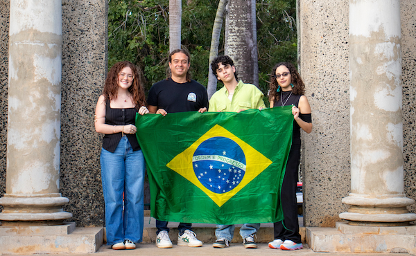 Desde la izquierda y de pie frente al Pórtico del Colegio: Natalia S. Guilloty Rodríguez, el doctor Christian Rodríguez Vélez, Miguel A. Morales Ramos y Rachel S. Pérez Aquino, quienes representaron al RUM en el II Coloquio Internacional de Mitocrítica, celebrado en la Universidad Católica de Brasilia. Sostienen una bandera de Brasil.