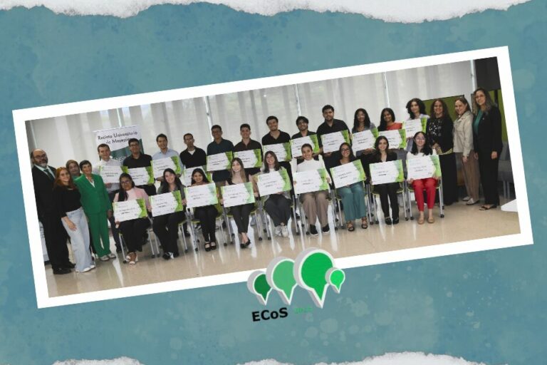 Grupo de becados de ECoS algunos sentados y otros de pie sostienen sus cheques simbólicos y están acompañados por funcionarios universitarios.