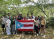 Participantes del Proyecto MODExL en su visita a una de las fincas con la bandera de Puerto Rico.