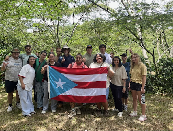 Participantes del Proyecto MODExL en su visita a una de las fincas con la bandera de Puerto Rico.