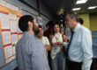 El doctor Raúl E. Torres Muñiz, coordinador del Programa de Afiliados a la Industria, conversa con un grupo de estudiantes durante la más reciente reunión. Todos de pie, frente al afiche de investigación grupal.