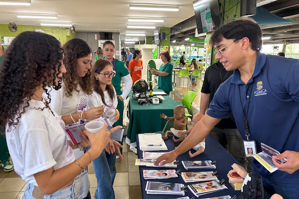 Portada La Oficina de Calidad de Vida del Recinto Universitario de Mayagüez celebró la Feria de bienestar y salud mental. Portavoces de la Administración de Salud Mental y Contra la Adicción (ASSMCA) conversan con estudiantes en su mesa de información.